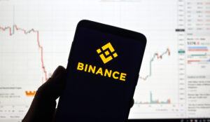 Screenshot von Kursverläufen und ein Handy mit der Binance App