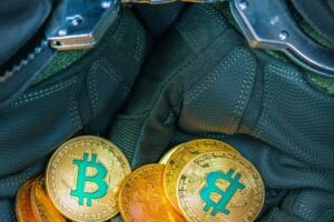 Gefesselte Hände halten Bitcoin