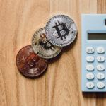 Bitcoin Münzen neben einem Taschenrechner als Bild für die Haltefrist