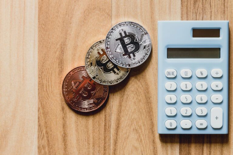 Bitcoin Münzen neben einem Taschenrechner als Bild für die Haltefrist